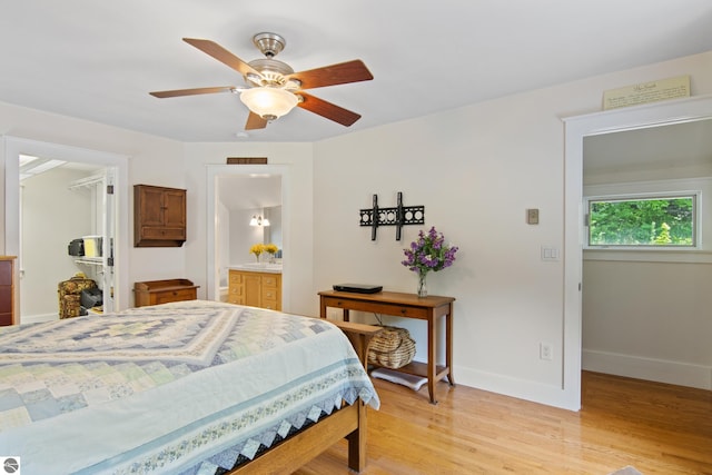1740 Setterbo Rd, Suttons Bay, MI 49682 - bedroom featuring a walk in closet, light wood-style flooring, a closet, a ceiling fan, and ensuite bath