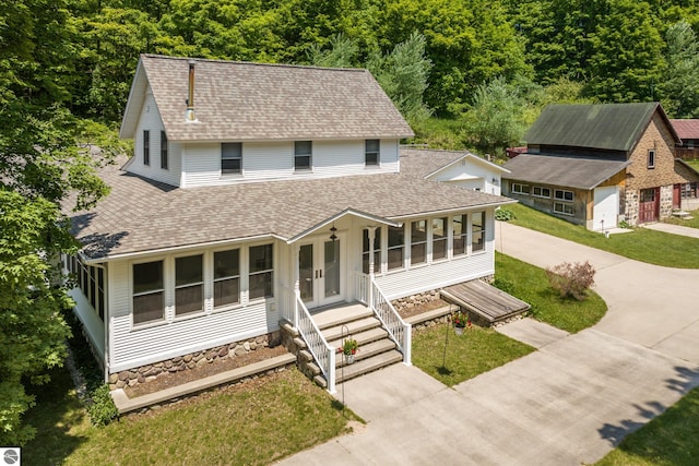 1740 Setterbo Rd, Suttons Bay, MI 49682 - view of front of home with roof with shingles, driveway, a front lawn, and a view of trees