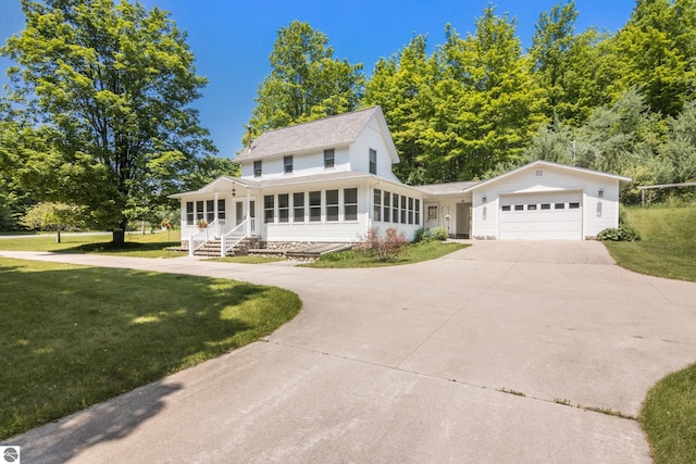 1740 Setterbo Rd, Suttons Bay, MI 49682 - view of front of home with concrete driveway, a front lawn, an attached garage, and roof with shingles