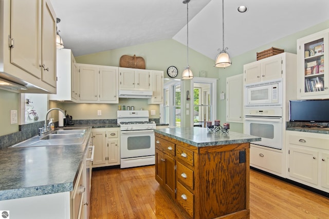 1740 Setterbo Rd, Suttons Bay, MI 49682 - kitchen with white appliances, under cabinet range hood, dark countertops, wood finished floors, and high vaulted ceiling