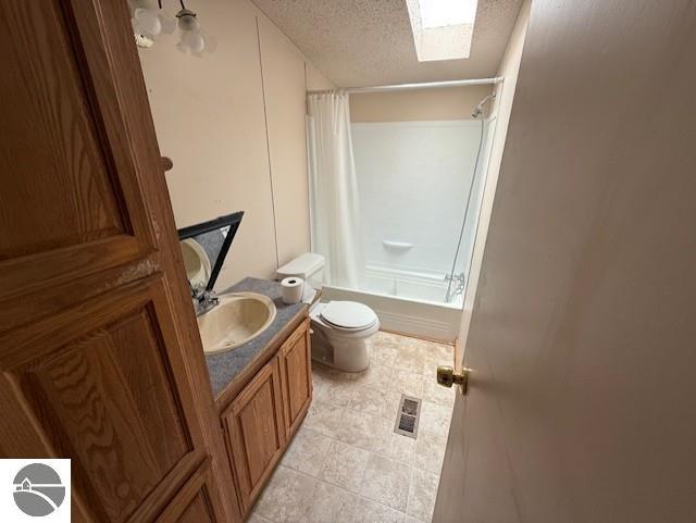 7372 Clans St, Alma, MI 48801 - bathroom with a textured ceiling, vanity, shower / bath combo, and tile patterned floors