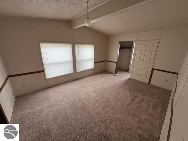 7372 Clans St, Alma, MI 48801 - unfurnished bedroom featuring a textured ceiling, carpet, and a decorative wall