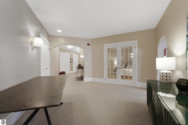 141 Rivers Edge Dr Unit 310, Traverse City, MI 49684 - living room with french doors, light carpet, arched walkways, and recessed lighting