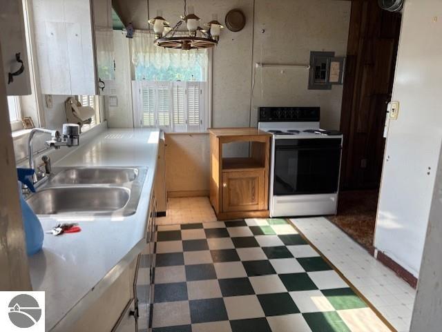 4161 Elbow Lake Rd, Prescott, MI 48756 - kitchen featuring electric range, light flooring, brown cabinets, a chandelier, and light countertops