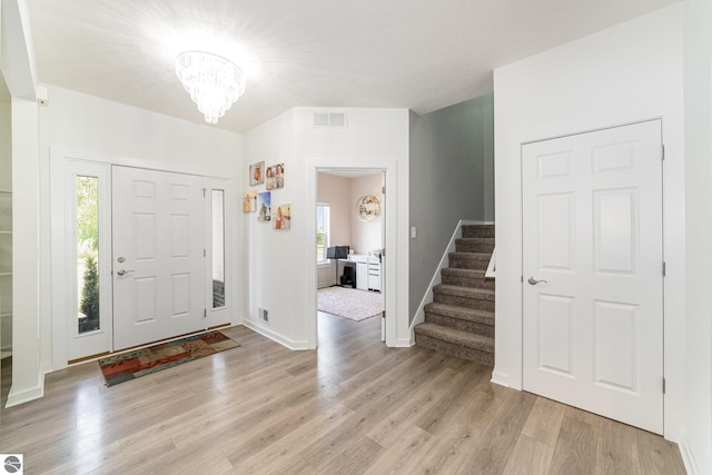 3468 Kali Ln, Alma, MI 48801 - entrance foyer with light wood-type flooring, stairway, and a chandelier