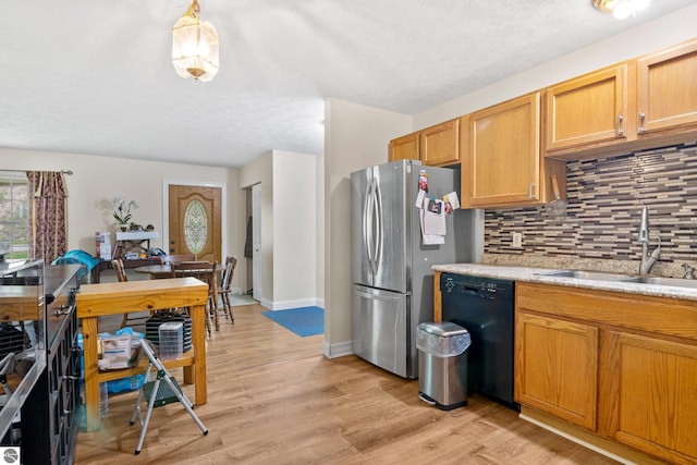 2733 Windcrest Ln, Traverse City, MI 49686 - kitchen featuring dishwasher, tasteful backsplash, freestanding refrigerator, and light wood-type flooring