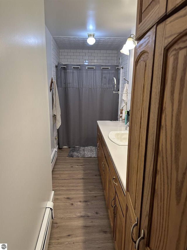 1339 S Melita Rd, Sterling, MI 48659 - bathroom featuring curtained shower, vanity, wood finished floors, and a baseboard heating unit