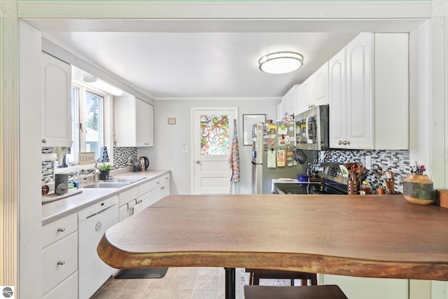 821 Indian Trail Blvd, Traverse City, MI 49686 - kitchen with stainless steel appliances, tasteful backsplash, white cabinets, a peninsula, and a kitchen bar