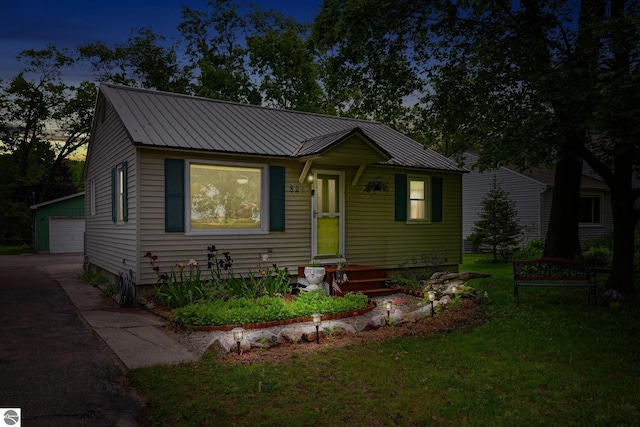 821 Indian Trail Blvd, Traverse City, MI 49686 - bungalow-style home featuring a metal roof, an outdoor structure, a detached garage, and a front lawn