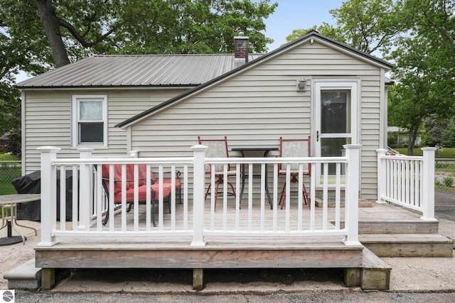821 Indian Trail Blvd, Traverse City, MI 49686 - back of property featuring a deck, a metal roof, and a chimney
