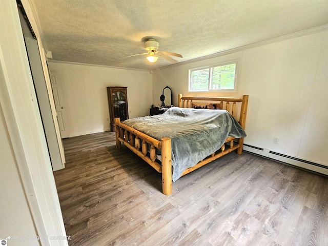 622 W Houghton Lake Rd, Lake City, MI 49651 - bedroom with crown molding, wood finished floors, a baseboard heating unit, a textured ceiling, and ceiling fan