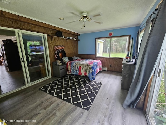 622 W Houghton Lake Rd, Lake City, MI 49651 - bedroom featuring wood walls, wood finished floors, baseboard heating, a textured ceiling, and crown molding