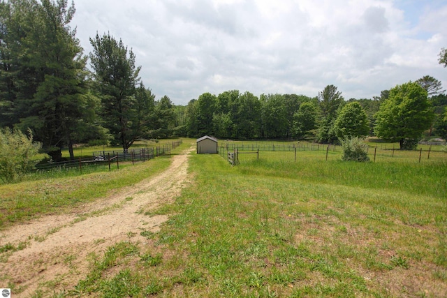 8124 Crisp Rd, Williamsburg, MI 49690 - view of yard featuring a rural view, an outdoor structure, a forest view, and an outbuilding