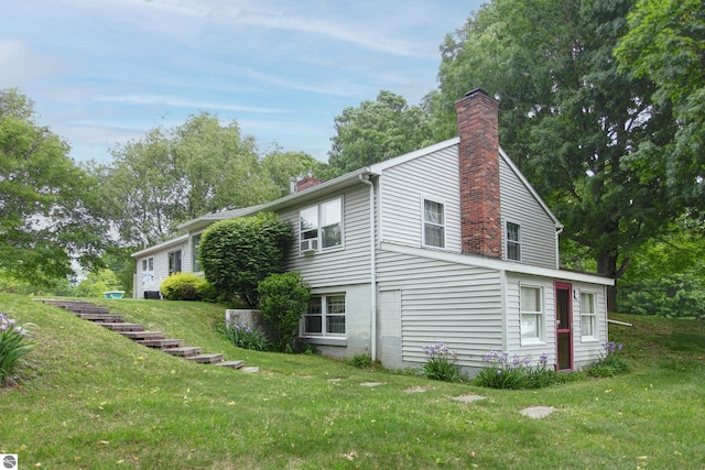 8124 Crisp Rd, Williamsburg, MI 49690 - view of side of home with a chimney and a lawn