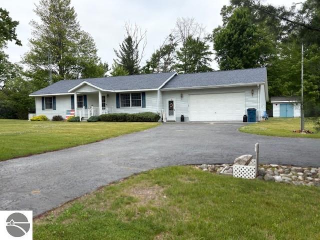 2615 Antelope Trl, West Branch, MI 48661 - ranch-style home featuring a garage, covered porch, a front lawn, and driveway