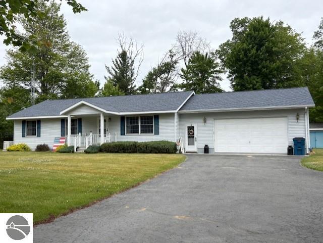 2615 Antelope Trl, West Branch, MI 48661 - single story home featuring covered porch, a garage, driveway, and a front lawn