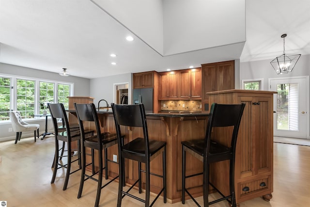 4180 Pintail Dr, Traverse City, MI 49696 - kitchen featuring recessed lighting, light wood-type flooring, fridge with ice dispenser, dark countertops, and a chandelier