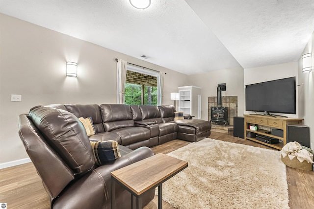4180 Pintail Dr, Traverse City, MI 49696 - living area featuring a wood stove, wood finished floors, and a textured ceiling