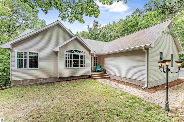 4180 Pintail Dr, Traverse City, MI 49696 - rear view of house with a lawn and a shingled roof