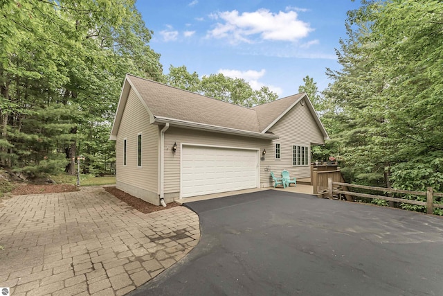 4180 Pintail Dr, Traverse City, MI 49696 - view of property exterior featuring driveway, a garage, and roof with shingles