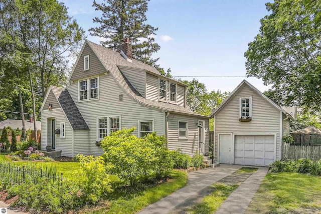 701 Sixth St, Traverse City, MI 49684 - view of front of house with a shingled roof, a chimney, and driveway