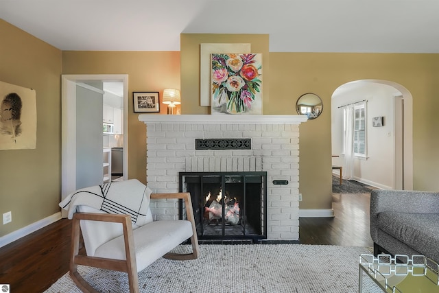 701 Sixth St, Traverse City, MI 49684 - living room with arched walkways, wood finished floors, and a brick fireplace