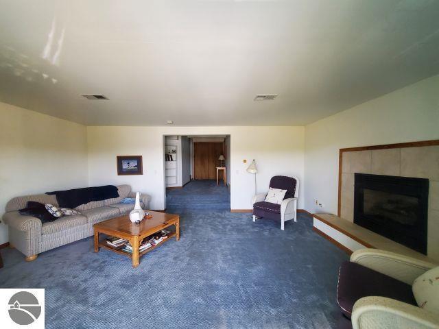 5736 Greenwood Rd, Gladwin, MI 48624 - living area featuring carpet floors and a fireplace