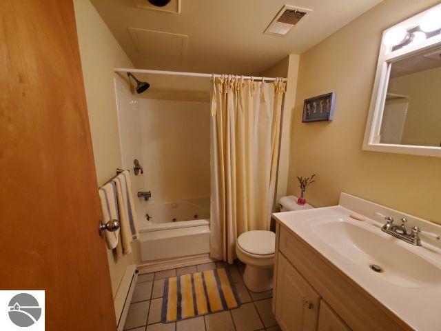 5736 Greenwood Rd, Gladwin, MI 48624 - bathroom with vanity, tile patterned flooring, and shower / bath combo