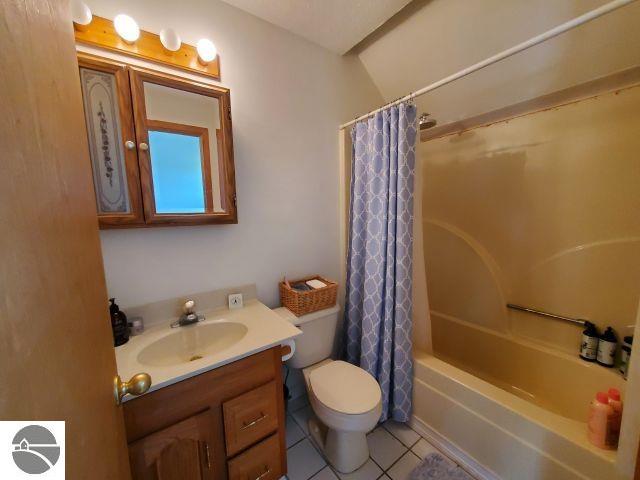 5736 Greenwood Rd, Gladwin, MI 48624 - full bath featuring tile patterned floors, vanity, and shower / bath combo