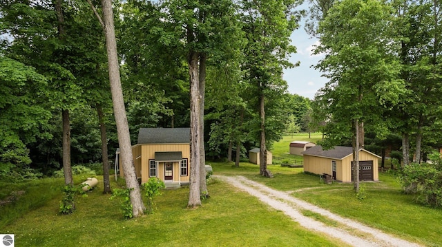 10090 E 48th Rd, Cadillac, MI 49601 - exterior space with dirt driveway, an outbuilding, a front lawn, and a garage