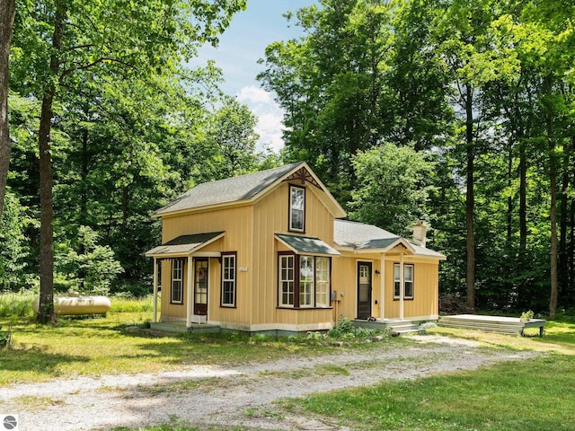 10090 E 48th Rd, Cadillac, MI 49601 - view of front of property with roof with shingles, a chimney, and a front yard