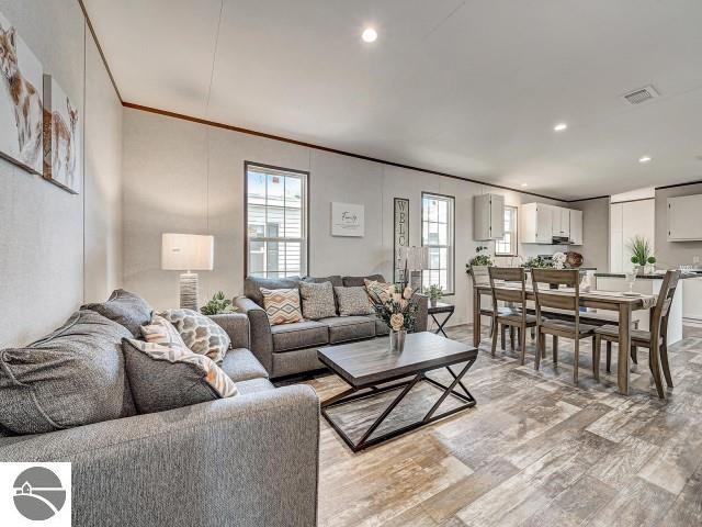 11399 Union St, Fife Lake, MI 49633 - living area featuring light wood-style floors, plenty of natural light, recessed lighting, and crown molding