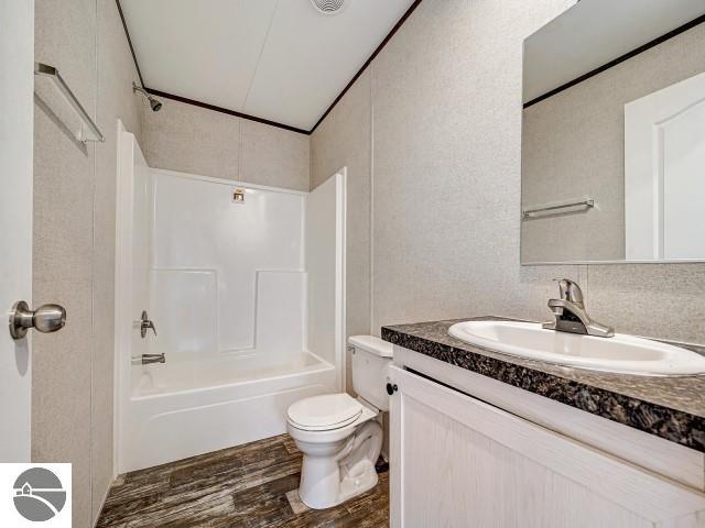 11399 Union St, Fife Lake, MI 49633 - bathroom featuring vanity, wood finished floors, and shower / washtub combination