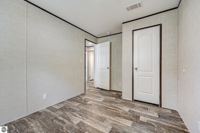 11399 Union St, Fife Lake, MI 49633 - unfurnished bedroom featuring wood finished floors and a decorative wall