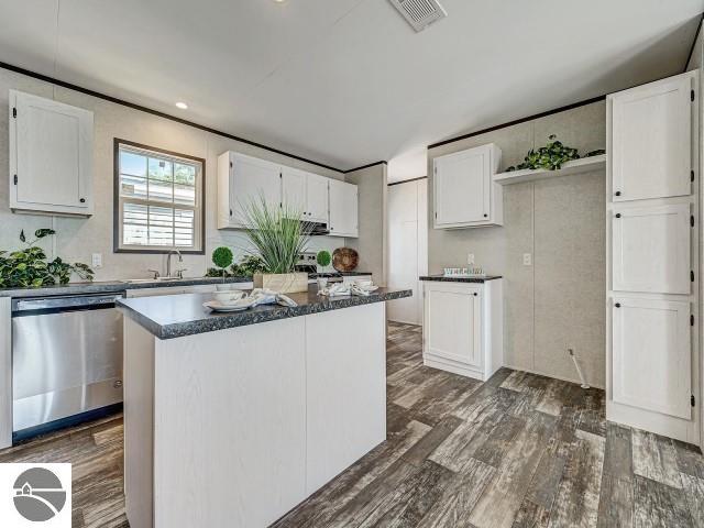 11399 Union St, Fife Lake, MI 49633 - kitchen featuring dishwasher, dark wood-style flooring, and white cabinets