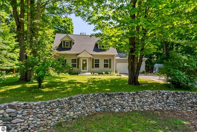 2491 Holland Cir, Traverse City, MI 49685 - cape cod-style house featuring a garage, a front lawn, and driveway