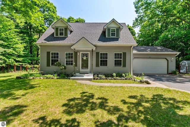 2491 Holland Cir, Traverse City, MI 49685 - cape cod-style house with asphalt driveway, a garage, a front yard, and a shingled roof