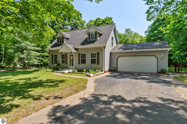 2491 Holland Cir, Traverse City, MI 49685 - cape cod-style house with driveway, an attached garage, a front lawn, and roof with shingles
