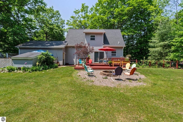 2491 Holland Cir, Traverse City, MI 49685 - back of house featuring a fire pit, a wooden deck, and a lawn
