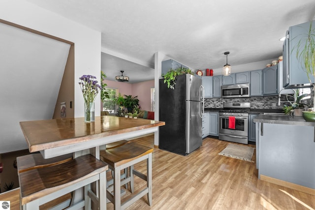 2491 Holland Cir, Traverse City, MI 49685 - kitchen with appliances with stainless steel finishes, backsplash, dark countertops, gray cabinets, and light wood-style floors