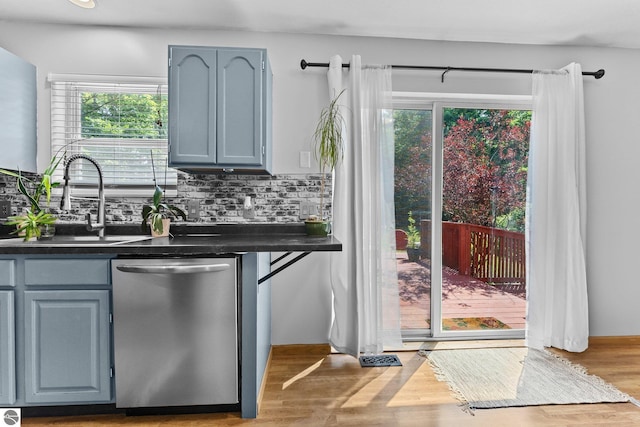 2491 Holland Cir, Traverse City, MI 49685 - kitchen featuring dishwasher, dark countertops, backsplash, and wood finished floors