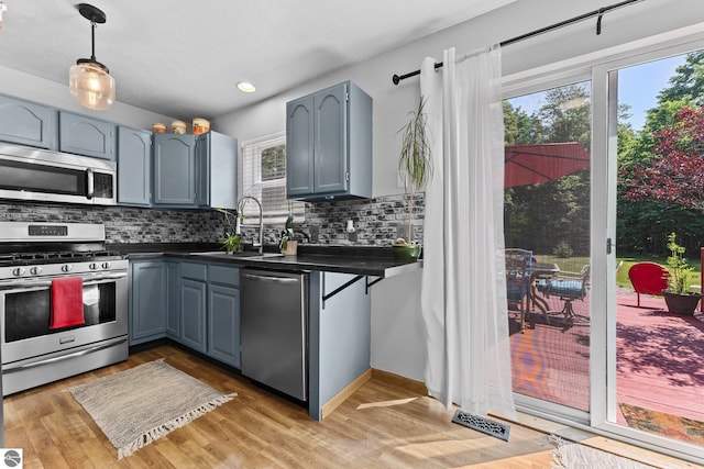 2491 Holland Cir, Traverse City, MI 49685 - kitchen with appliances with stainless steel finishes, dark countertops, backsplash, decorative light fixtures, and recessed lighting