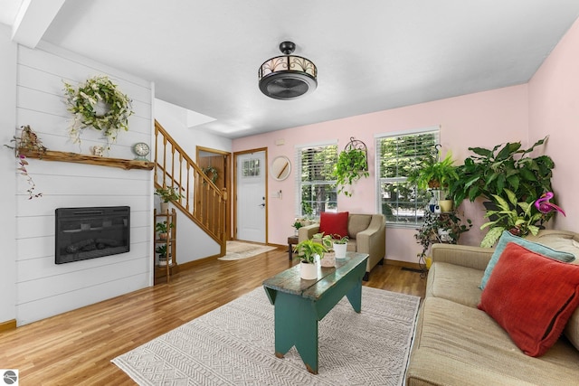 2491 Holland Cir, Traverse City, MI 49685 - living room with stairway, wood finished floors, and a glass covered fireplace