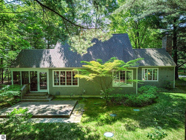 4079 E Oxford Dr, Leland, MI 49654 - rear view of house featuring a patio area, a chimney, a shingled roof, and a yard