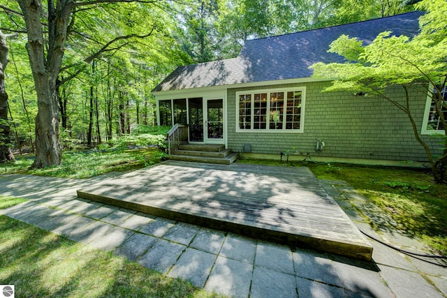 4079 E Oxford Dr, Leland, MI 49654 - rear view of property featuring a shingled roof and a deck