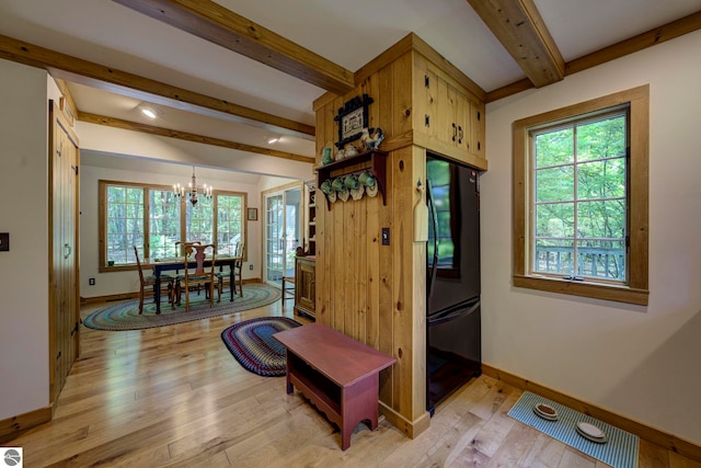 4079 E Oxford Dr, Leland, MI 49654 - entrance foyer featuring beam ceiling, a chandelier, healthy amount of natural light, and light wood-style floors