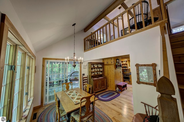4079 E Oxford Dr, Leland, MI 49654 - dining space with vaulted ceiling, light wood-type flooring, and a chandelier