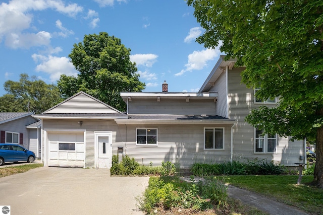 503 N Kinney Ave, Mount Pleasant, MI 48858 - view of front facade with a chimney, driveway, and a garage