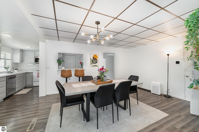 503 N Kinney Ave, Mount Pleasant, MI 48858 - dining space featuring dark wood-style flooring, a drop ceiling, and a chandelier