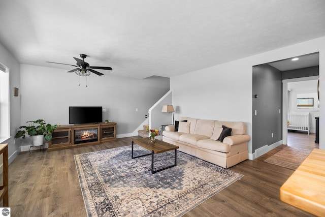 6330 Lund Rd SW, Fife Lake, MI 49633 - living room with radiator heating unit, wood finished floors, a ceiling fan, stairway, and recessed lighting